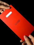 Red envelope with Sentinote branding held by hands against a black background